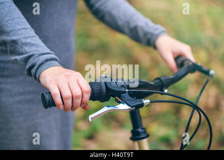 La femme pose avec son vélo dans le parc en automne Banque D'Images