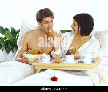 Lit, couple, petit-déjeuner, à l'intérieur, chambre à coucher, les jeunes, le contact oculaire, prendre le petit-déjeuner, tombe amoureux, heureux, l'amour, à la maison, gâter Banque D'Images