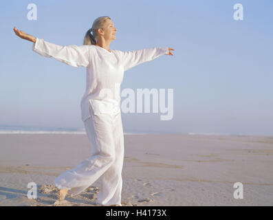 Plage de sable fin, femme, Taïchi, meilleur âge, de 50 à 60 ans, la plage, la mer, les loisirs, hobby, pratique, méditative, motion, motion, séquences, exercices, lentement, couramment, les haut-parleurs de l'ombre, "libre circulation circulation', l'équilibre, l'activité, conscience du corps, la méditation, le Tai Banque D'Images