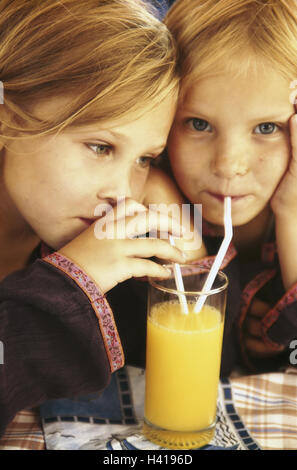 Les enfants, les filles, le verre, le jus d'Orange, boisson, portrait, sœurs, amis, frères et soeurs, blonde, s'asseoir, boire, sains, de la paille, du jus, de boire, de vitamines, riches en vitamines, les jus de fruits Banque D'Images
