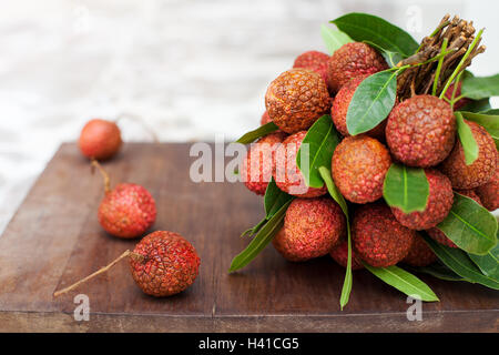 Le litchi avec des feuilles sur une planche en bois Copy space Banque D'Images