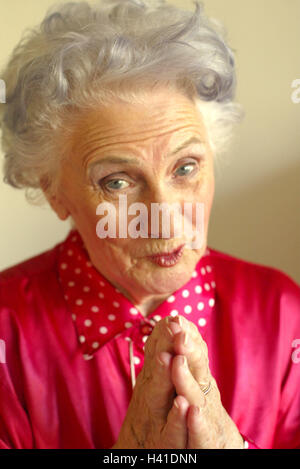 Les cadres supérieurs, les mains, espérons-le, portrait, 60 ou 70 ans, femme, pensionné, vieille personne, vieux, aux cheveux gris, cheveux blancs, un chemisier rouge, voir l'appareil photo, demandez, l'espoir, s'attendre, l'attente, l'espoir, la confiance, l'équilibre, de satisfaction, sourire, l'humeur positive, à l'intérieur Banque D'Images