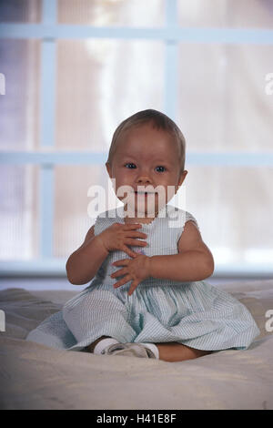 Bébé, lit, assis, heureux, très proche, à la maison, enfant, nourrisson, girl, l'enfance, heureuse, gaieté, de gestes, de couleurs vives, les hautes exigences (3 étoiles) Banque D'Images