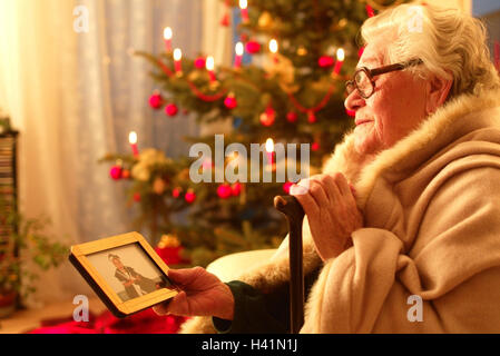 Salons, canapé, senior, plafond, enveloppé, marbre, photographie, look, l'intérieur, à la maison, Noël, yule marée, pour Noël, la veille de Noël, la veille de Noël, arbre de Noël, des bougies, des brûlures, femme, vieux, retraité, vieille personne, de vieux hommes, vieille femme, seulement, lonel Banque D'Images