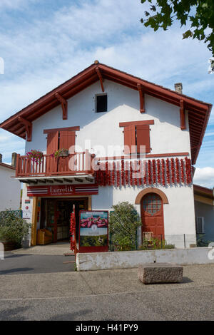 Boutique de produits locaux dans une maison typique à Espelette avec poivrons rouges séchant sur façade. Pays Basque. La France. Banque D'Images