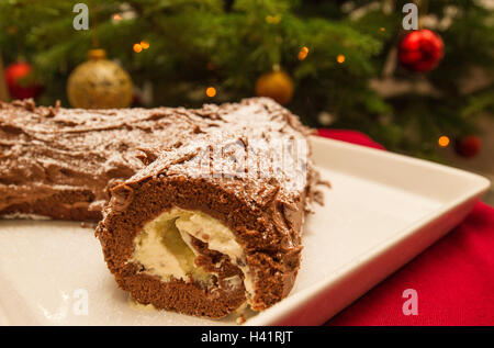 Bûche de Noël en face de l'arbre avec baubles Banque D'Images