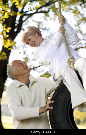 Couple, balançoire, corde, pneu automobile, swing, plaisir, contact avec les yeux, heureux, fondu, 50-60 ans, 60-70 ans, en couple, les personnes âgées, les retraités, meilleur âge, saine, active, mettre en place, activement, agile, Jung-solde, loisir, Parc, jardin, gaieté Banque D'Images