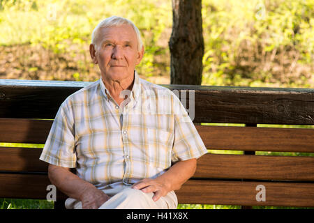 Un homme âgé assis sur un banc. Banque D'Images