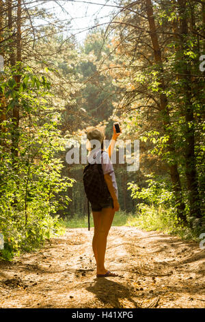 Photographier les arbres forestiers Caucasian woman with cell phone Banque D'Images