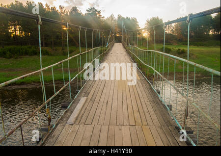 Rayons de soleil sur la passerelle en bois sur la rivière Banque D'Images