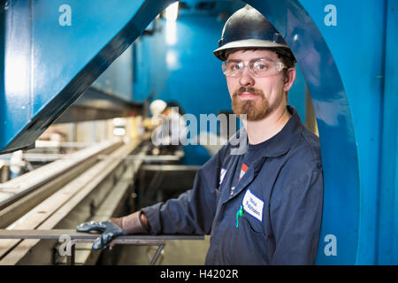 Caucasian worker posing in factory Banque D'Images