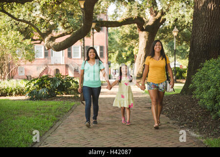 La mère et les filles hispaniques walking in park Banque D'Images