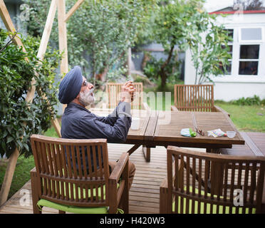 Indian man photographing with cell phone on patio dans L Banque D'Images