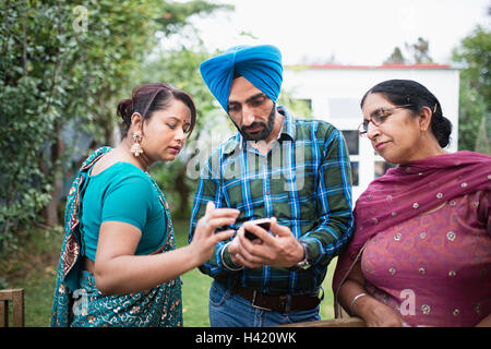 Famille texting on cell phone outdoors Banque D'Images