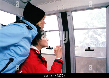 Gondola, couple, jeune, des vêtements d'hiver, vue, vue latérale, vacances, vacances de ski, vacances d'hiver, saison, hiver, neige, hiver, vêtements, vêtements, vêtements de ski, remontées mécaniques, ascenseur, téléphérique, de 20 à 30 ans, temps de loisirs, voir, la curiosité Banque D'Images