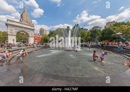 L'Arche de Washington Square Park, à New York et des personnes jouant dans l'eau de la fontaine. Banque D'Images