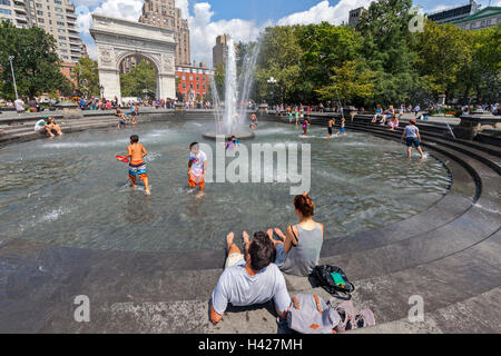 L'Arche de Washington Square Park, à New York et des personnes jouant dans l'eau de la fontaine. Banque D'Images