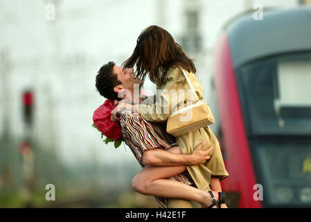 La plate-forme, couple, embrasser, souhaits, bouquet, joie, fondu de la gare, train, voyage, retour, accueillir, présenter, fleurs, joie de voir encore une fois, la réunion, l'amour, l'affection, les sentiments, les émotions de colère, d'enthousiasme, de gaieté, émotion, enthousiasme, reçu, Banque D'Images