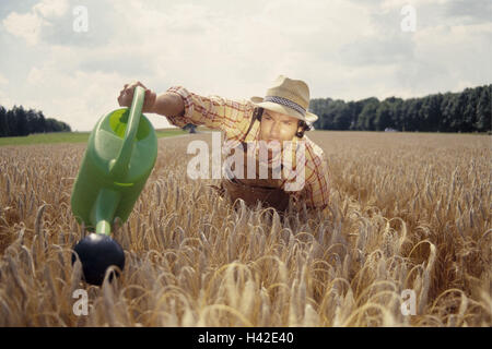 Farmer, le socle, le champ d'orge, grain, arrosoir, jeter l'agriculture, domaine, champ de céréales, de grains, pion, agriculteur, les jeunes, l'orge, Hordeum, icône, sécheresse, sèchement, l'irrigation, l'eau, travailler dans les champs, de combinaisons, de soins, de soucis, de profit, de soins, de soins supplémentaires Banque D'Images