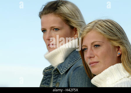 Amis, afficher, profiter, side view, portrait, portrait de femmes, les femmes, les deux, de 20 à 30 ans, blonde, poil long, ensemble, l'amitié, attention tenez, vue, d'observation, le temps libre, le vent, les poils, blow, vêtements, autumnally Rouleau, Rouleau, cou cou pull-overs, ciel, bleu clair Banque D'Images