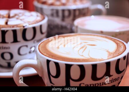 Quatre tasses de Cappuccino avec de la mousse et décorées bokeh Banque D'Images