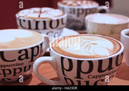 Quatre tasses de Cappuccino avec de la mousse et décorées bokeh Banque D'Images