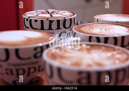 Quatre tasses de Cappuccino avec de la mousse et décorées bokeh Banque D'Images