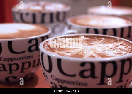 Quatre tasses de Cappuccino avec de la mousse et décorées bokeh Banque D'Images