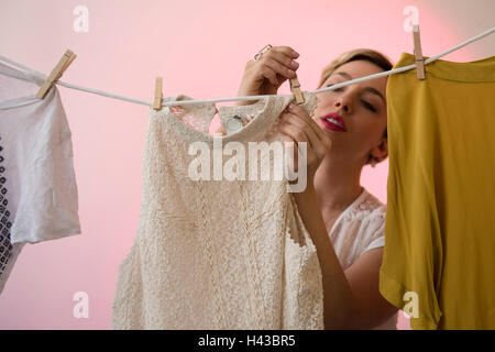 Caucasian woman hanging shirts sur corde à linge avec Banque D'Images