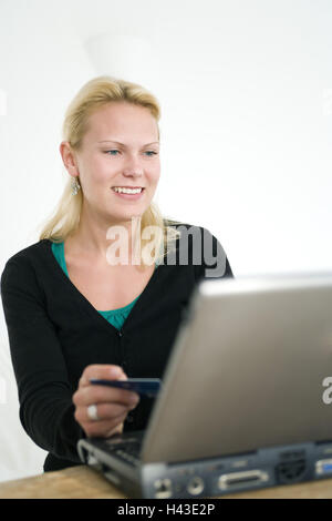 Jeune femme, sourire, ordinateur portable, carte de crédit, voir moniteur, Banque D'Images