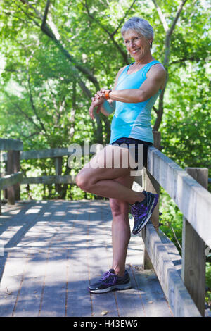 Caucasian woman leaning on wooden fence contrôle du temps Banque D'Images