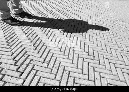 Image en noir et blanc du trottoir en brique avec motif homme debout à l'extérieur de la Cooper Hewitt, Smithsonian Museum of Design Banque D'Images