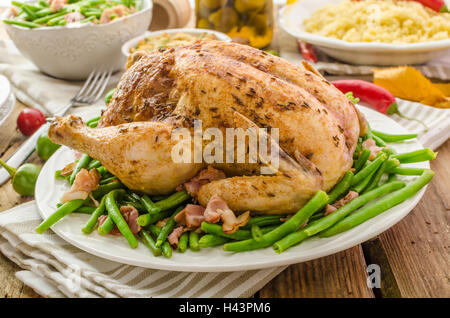 Poulet farci au four avec des herbes et des piments, le couscous et les fèves au lard jeunes délicieux Banque D'Images