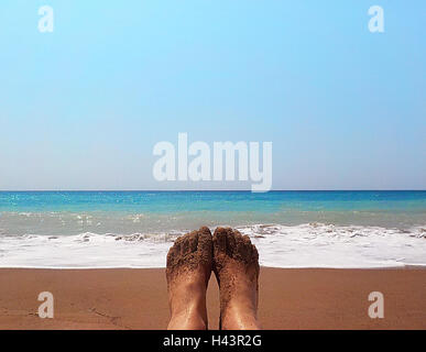 Pieds de femme couverte de sable sur plage Banque D'Images