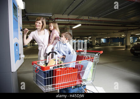 Parc de stationnement garage, distributeur automatique, femme, enfants, logement, chariots de magasinage, Banque D'Images