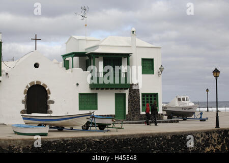 L'Espagne, les Canaries, l'île de Lanzarote, La Caleta de Famara, port, chambre, la destination, l'île volcan, lieu, bâtiment, architecture, église, croix, bande, des navires, des bottes, des gens, des passants, à l'extérieur, Banque D'Images