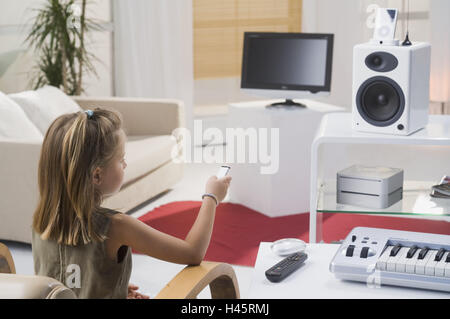 Salle de séjour, girl, geste, longue distance-service, vue de dos, pas de biens, personnes, enfant, 6 ans, de l'enfance, plat, LCD-TV-set, haut-parleurs, Mac mini, iPod vidéo, Apple Remote, l'électronique, électro-appareils, la technologie, la conversation, la conversation Banque D'Images