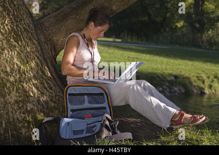 Femme, assis, log, maigre, Apple iBook, d'entrée de données, sac, ni des biens, série, gens, parc, étudiant, jeune, pleine longueur, de 20 à 30 ans, les ordinateurs, Mac, MacBook, ordinateur portable, les données, le traitement des données, flexibilité, mobilité, portable, sans fil, sur le chemin, Banque D'Images