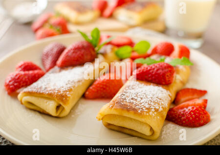 Blintzes - crêpes au fromage riccota rempli et creame fraîche avec des fruits frais et de menthe Banque D'Images