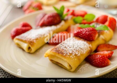 Blintzes - crêpes au fromage riccota rempli et creame fraîche avec des fruits frais et de menthe Banque D'Images