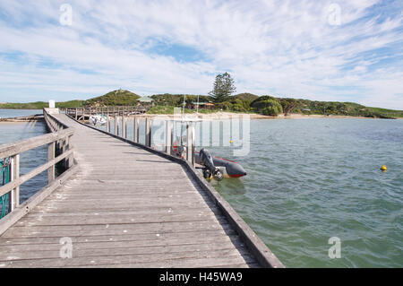 Entrée de la jetée de l'Île Penguin avec des bateaux, les dunes et les eaux de l'Océan indien sous un ciel bleu avec des nuages dans l'ouest de l'Australie. Banque D'Images