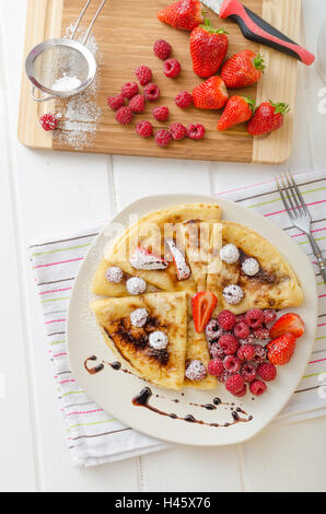 Des crêpes faites maison avec la réduction de vinaigre balsamique et de fruits frais, fraises et framboises Banque D'Images