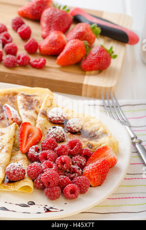 Des crêpes faites maison avec la réduction de vinaigre balsamique et de fruits frais, fraises et framboises Banque D'Images