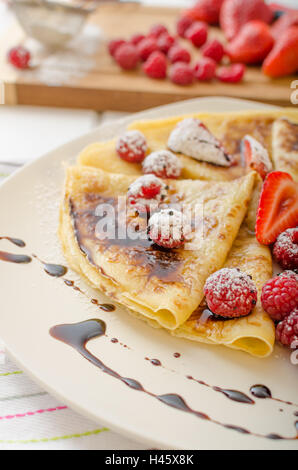 Des crêpes faites maison avec la réduction de vinaigre balsamique et de fruits frais, fraises et framboises Banque D'Images