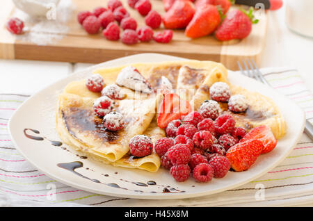 Des crêpes faites maison avec la réduction de vinaigre balsamique et de fruits frais, fraises et framboises Banque D'Images