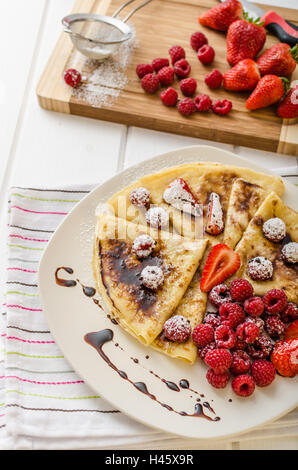 Des crêpes faites maison avec la réduction de vinaigre balsamique et de fruits frais, fraises et framboises Banque D'Images