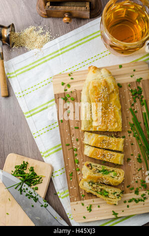 Strudel aux épinards, fromage bleu et l'ail, saupoudré de sésame et de ciboulette Banque D'Images