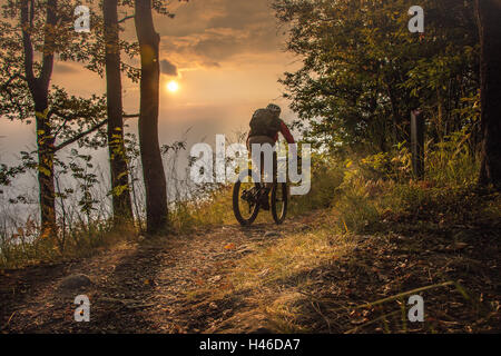 Vélo de montagne jusqu'au coucher du soleil Banque D'Images