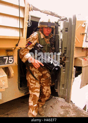 13 avril 2003 un soldat britannique de l'Irish Guards quitte la porte arrière du véhicule de combat d'un guerrier à Bassora, en Irak. Banque D'Images