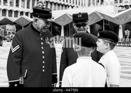 Deux retraités Chelsea parler aux jeunes cadets de la à l'Pearly Kings and Queens' Harvest Festival, le Guildhall, Londres, UK Banque D'Images